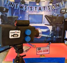 a television camera sitting on top of a table next to a sign that says news station