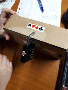 a person holding a lock on top of a cardboard box