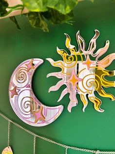 a paper sun and moon hanging on a green wall