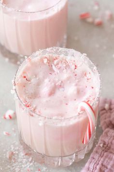 two glasses filled with candy cane milkshakes on top of a white countertop