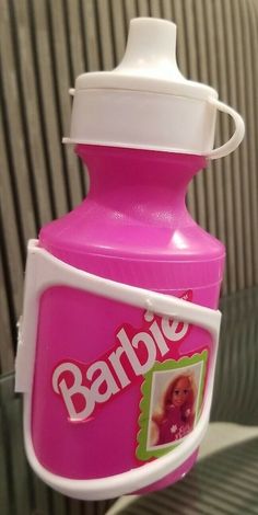 a pink baby bottle sitting on top of a glass table