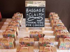 many small boxes are tied together and placed on a table with a sign that says baggage claim thank you for coming