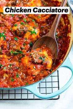 a pan filled with meatballs and sauce on top of a cooling rack next to a wooden spoon