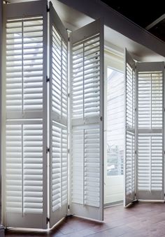 a room divider with white shutters in it