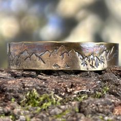 Whether you're looking for a birthday gift, or celebrating your anniversary, a thoughtful gift is a must! This solid bronze cuff bracelet is the perfect answer.  Side note: bronze is the traditional gift for both 8th and 19th anniversary.  This handmade bronze bracelet features stamped images of mountains and trees, which celebrate the natural beauty and majesty of the forest. It is ideal for outdoor enthusiasts such as hikers and hunters. Each piece is unique due to the hand-forged process and Spiritual Copper Bangle As Gift, Spiritual Bronze Jewelry For Anniversary, Engraved Bronze Rings Ideal For Gifts, Bronze Engraved Rings Ideal For Gifts, Bronze Engraved Rings For Gift, Engraved Bronze Rings Gift, Hand Forged Bronze Cuff Bracelet Gift, Hand Forged Bronze Cuff Bracelet For Gift, Bronze Hand Forged Cuff Bracelet As Gift