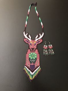 a beaded necklace and earring set on a black table with a white background