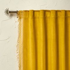 a yellow curtain hanging on the side of a white wall