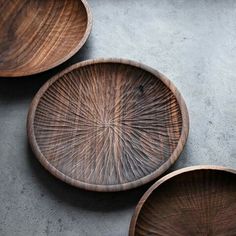 three wooden plates sitting on top of a cement floor