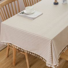 a table with a book, coffee cup and saucer on it next to two chairs