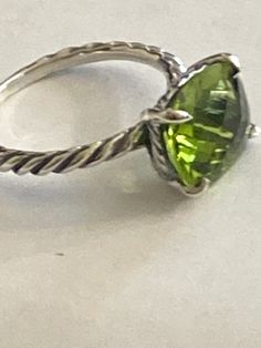 Previously USED  David Yurman Cushion Ring size 7 100% AUTHENTIC  COLOR STONE RING COLLECTION  Ring has been cleaned  Estimated Retail $395-$695 12mmx10mm  Faceted Center Stone  PERIDOT  -DY Checkerboard Faceting  925 Sterling Silver    usps Signature+ Insurance   Item must be packed in original condition and packed with original contents Luxury Oval Peridot Rings, Luxury Peridot Rings With Accent Stones, Elegant Peridot Gemstone Stackable Rings, Elegant Green Peridot Stackable Rings, Elegant Peridot Stackable Rings For May Birthstone, Green Stackable Rings For Formal Occasions In May, Green Stackable Rings For Formal May Birthstone, Green Formal Stackable Rings For May Birthstone, Green Peridot Stackable Rings