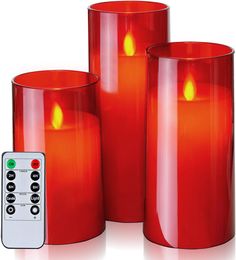 three red candles are next to a remote control