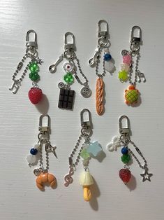 six different key chains with charms attached to them