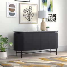 a living room with pictures on the wall and a rug in front of an entertainment center