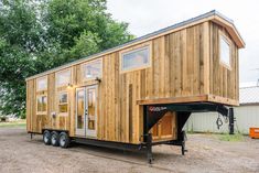 a tiny house on wheels is parked in a lot