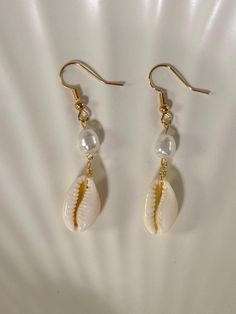 - Gold plated ✨ - Lead and nickel free 🤍 - Real cowrie seashell 🐚 - Each seashell is unique and straight from the ocean/beach 🏝️ - Please note that sometimes seashells have impurities -- they are imperfectly perfect 💖 Cheap Beige Earrings For Beach, Cheap Shell Drop Earrings, Diy Dangling Earrings, Handmade Shell Earrings For Beach Season, Vacation Dangle Shell Jewelry, Vacation Shell Dangle Jewelry, White Shell Jewelry For Beach Season, Beach Shell Dangle Earrings, Shell Dangle Earrings For Beach