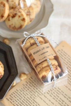 some cookies are wrapped in paper and sitting on a table next to an open book