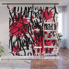 a wall mural with red and black graffiti on it in an empty room next to a ladder