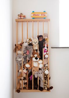 stuffed animals are stored in a wooden rack on the wall next to a shelf with a sign that says roll o'clock