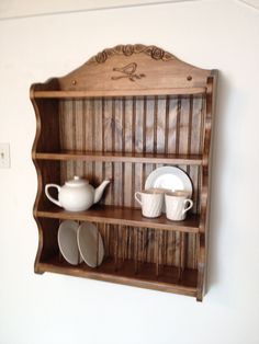 a wooden shelf with dishes and cups on it