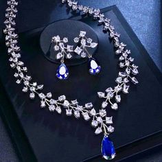 Make a statement with our Lab-Created Blue Sapphire Stone Necklace Earrings Set, plated with 18K white gold. 💙 💎 The oval-shaped blue sapphire gemstones add a touch of elegance and sophistication to any outfit. Shop now and complete your look with this stunning jewelry set! ✨ #uniquefashionjewelryboutique #jewelry #jewelryaddict #jewelryforyou #diamond Deep Blue Necklace, Elegant Blue Dangle Jewelry Sets, Luxury Blue Dangle Jewelry, Blue Pendant Necklace With Matching Earrings, Sapphire Aesthetic, Sapphire Jewelry Set, Sapphire Diamond Necklace, Blue Stone Earrings, Blue Sapphire Stone