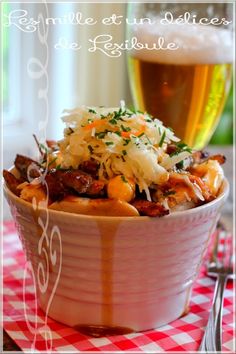 a bowl filled with food next to a glass of beer