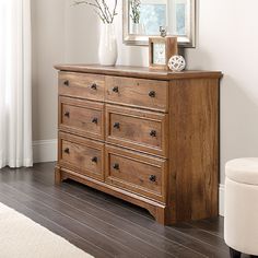 a wooden dresser sitting next to a window