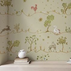 the wallpaper is decorated with animals and trees in gold, green, and white