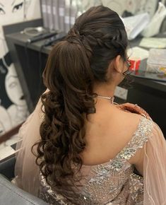 a woman sitting in a chair with her hair styled into a half - updo