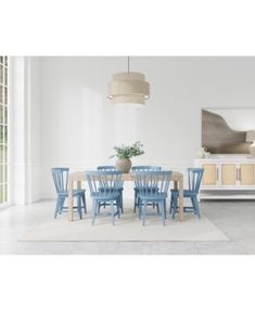 a dining room table with blue chairs and a white rug on the floor in front of it