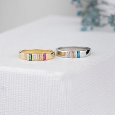 two different colored rings sitting on top of a white surface