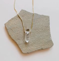 A striking crystal strung through slim heavily-plated 18kt gold chain, creating a daily space for self-care and wellness no matter what is on your plate. A statement making piece to wear alone, or layer up two or three for a unique and mindful look! Genuine Clear Quartz crystal point Point Approx 35mm length, 15mm width As with natural stones, each will vary in color and size 18k gold extra heavy plated Brass base Tarnish-free coating Made in United States of America Thank you for supporting Ame Minimalist Crystal Necklace For Healing, Minimalist Crystal Pendant Necklace With Delicate Chain, Everyday Gold Spiritual Crystal Necklace, Everyday Spiritual Gold Crystal Necklace, Gold Spiritual Crystal Necklace For Everyday, Everyday Spiritual Gemstone Crystal Necklaces, Minimalist Everyday Clavicle Chain Crystal Necklace, Minimalist Crystal Clavicle Chain Necklace, Minimalist Quartz Jewelry For Healing