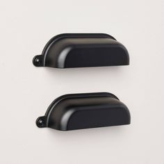 two black door handles on a white wall