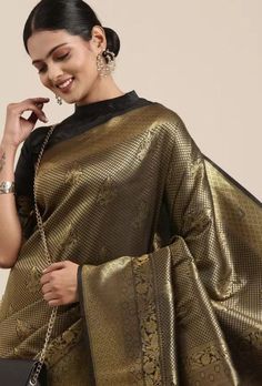 Elevate your traditional wardrobe with our Black & Gold-Toned Banarasi Saree. Crafted from a luxurious silk blend, this saree features intricate ethnic motifs and exquisite zari work, making it a perfect choice for weddings, festive occasions, and special events. The elegant combination of black and gold adds a touch of sophistication and timeless beauty to your ensemble. Drape yourself in this stunning saree to make a statement and embrace the rich heritage of Indian craftsmanship. Blouse: A Unstitched Blouse Material Is A Part Of All The Sarees. However, We Will Be Able To Customize Your Blouse As Per Your Measurements and Requirements. We Offer Additional Services Like Maggam/Zari/Embroidery Works As Per Your Requirement And Charged Accordingly. Please Reach Out To Us To Discuss On The Black Kanjivaram Saree Silk, Black Kanjivaram Saree, Gold Banarasi Saree, Designer Sarees Wedding, Ethnic Motifs, Indian Sarees Online, Designer Sarees Online, Party Kleidung, Banarasi Saree