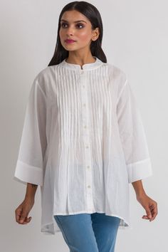 "Our Rajani Tunic is hand embroidered by women artisans in Northern India in the shadow-work style known as \"Chikankari\" on soft 100% cotton fabric. Chikankari is a delicate and artfully done hand embroidery technique that women in this region have been doing for generations. This elegant tunic features a Nehru collar, button down front with pleats, and exquisite hand embroidery on the back.  This style is free size, and is designed for a comfortable fit up to size XXL." Spring Handloom Chanderi Kurta, Traditional Festive Kurta With Pintucks, Festive Traditional Kurta With Pintucks, Traditional Straight Kurta With Pintucks, Traditional Pintucks Kurta, Cotton Tops With Pintucks And Relaxed Fit, Relaxed Fit Cotton Tops With Pintucks, Spring Cotton Kurta With Pintucks, Elegant Cotton Kurta With Cutdana