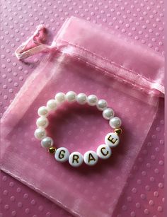 *This baby pearl bracelet can be personalized to say any name or initial(s) that you would like.* **Please keep in mind how long child's name is and if it's too long than I suggest using only an initial or initials.** *Please measure wrist before ordering.* **Please roll on bracelet rather than stretch on to prevent breaking.** *Bracelet will come in a cute drawstring bag ready for gifting.* Personalized Hypoallergenic Beaded Bracelets, Personalized Pearl Bracelet, Cute White Pearl Bracelet For Gift, Personalized White Stretch Bracelet As A Gift, White Name Bracelet For Personalized Gift, Cute White Pearl Bracelet Gift, Personalized Pearl Jewelry For Gift, White Name Bracelet Perfect As A Gift, Personalized Pearl Bracelets With Round Beads