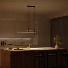 a kitchen with an island and bar stools next to the counter top in front of it