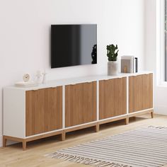 a flat screen tv mounted to the side of a wooden cabinet in a living room