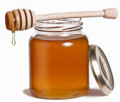 a jar of honey with a wooden spoon