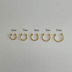 four pairs of gold nose rings on white background, with measurements for each pair in different sizes