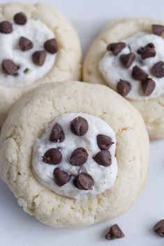 three cookies with chocolate chips and white frosting