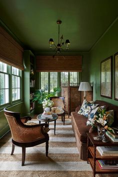 a living room filled with furniture and green walls