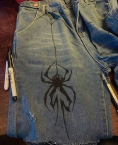 a pair of jeans with a spider drawn on it