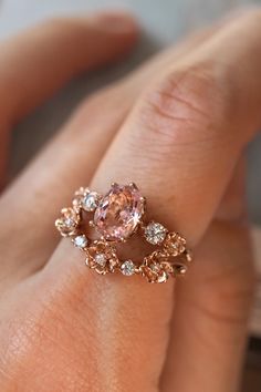 a close up of a person's hand holding an engagement ring