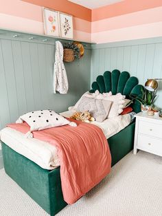 a bedroom with a green bed and pink walls