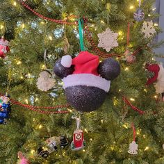 mickey mouse ornament hanging from the top of a christmas tree