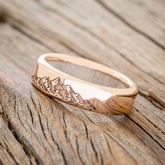 a gold ring with mountains engraved on it