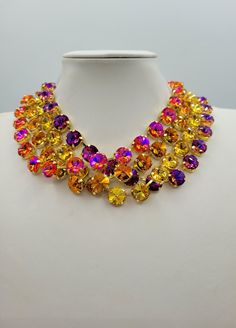 These Anna Wintour style statement necklaces are made with beautiful rivoli crystals in a range of colours, there is 12mm Violet Blue , 12mm Hyacinth, 12mm Topaz and 12mm Copper. The crystals are accentuated beautifully with the gold yellow setting. You can wear them separately or layer them all together for full impact,  sure to get compliments and attention. Their versatility makes them perfect for parties and other celebratory gatherings. Quality of the stones and settings makes them a perfect candidate for becoming heirloom pieces. It is elegant, classy and very "Anna Wintour style". Each necklace is accompanied by a pair of coordinated "FREE GIFT" earrings. -Crystals - 12mm Rivoli point back strass. -Crystal Colour - Violet Blue. -Necklace setting - Gold plated Brass (nickel, cadmium Luxury Multicolor Necklaces For Evening, Luxury Multicolor Pearl Necklace, Luxury Multicolor Elegant Beaded Necklaces, Luxury Statement Necklace With Colorful Beads, Luxury Multicolor Necklaces For Women, Elegant Luxury Multicolor Necklaces, Luxury Colorful Beads Statement Jewelry, Luxury Multicolor Beaded Necklaces For Party, Luxury Multicolor Beaded Necklaces For Celebration