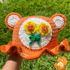 a crocheted teddy bear hat with flowers on it