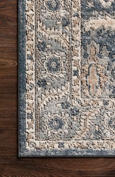 a blue and beige area rug on top of a wooden floor