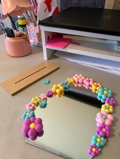 there is a mirror made out of candy beads on the table next to some scissors